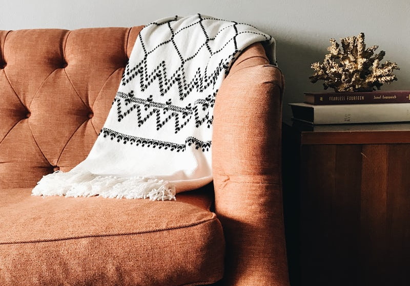 Orange couch draped with shawl